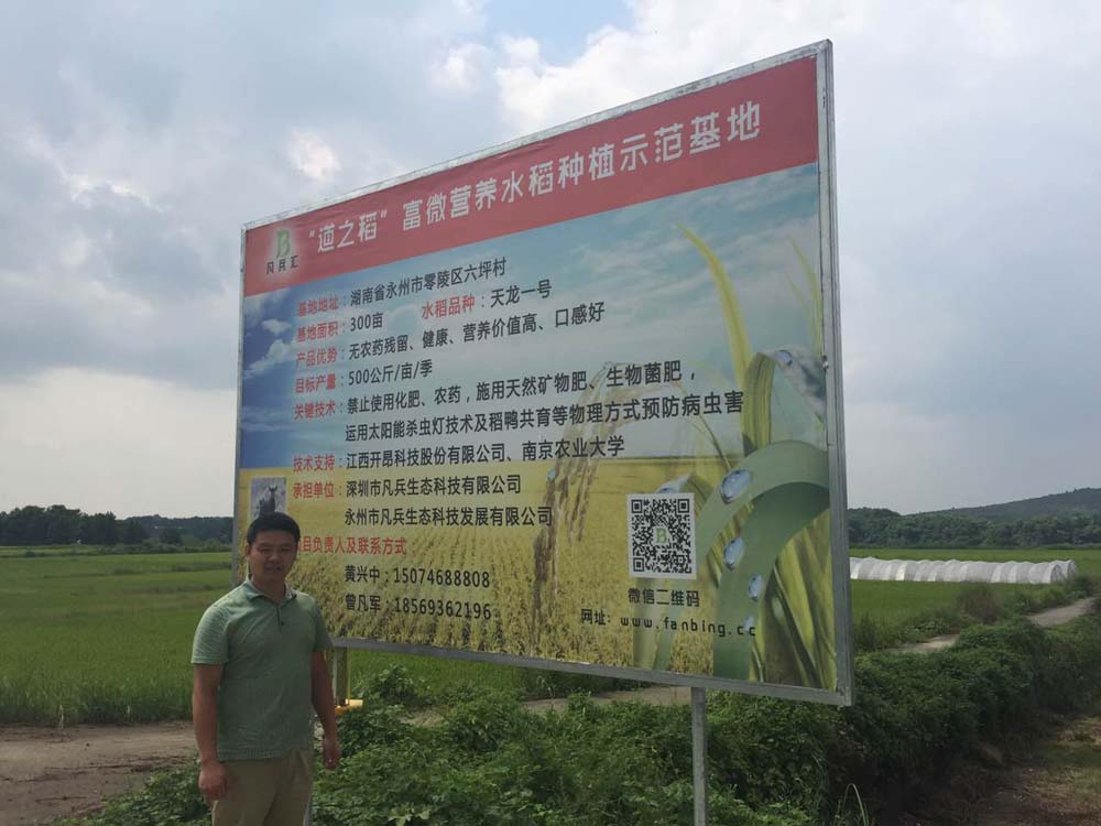 总经理唐云刚在零陵六坪村稻之道广告牌前合影.jpg
